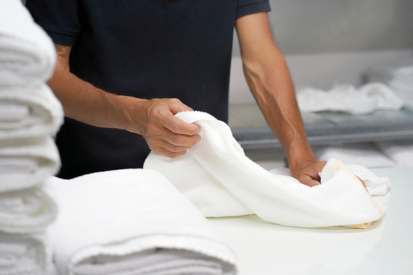 Commercial Laundry - Person Folding Towels